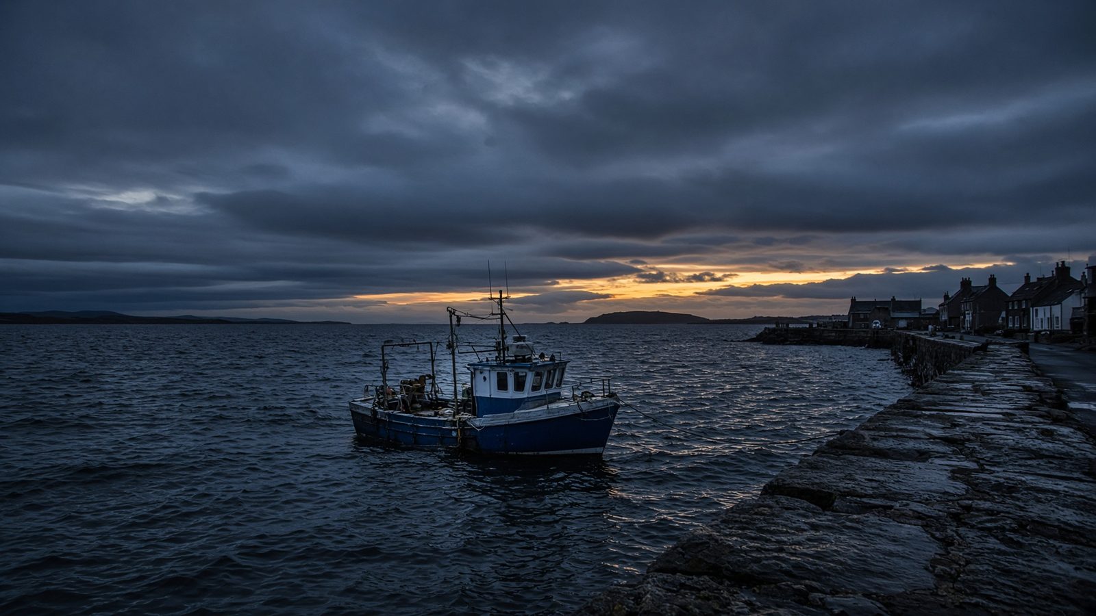 A small British harbour at dusk with choppy water